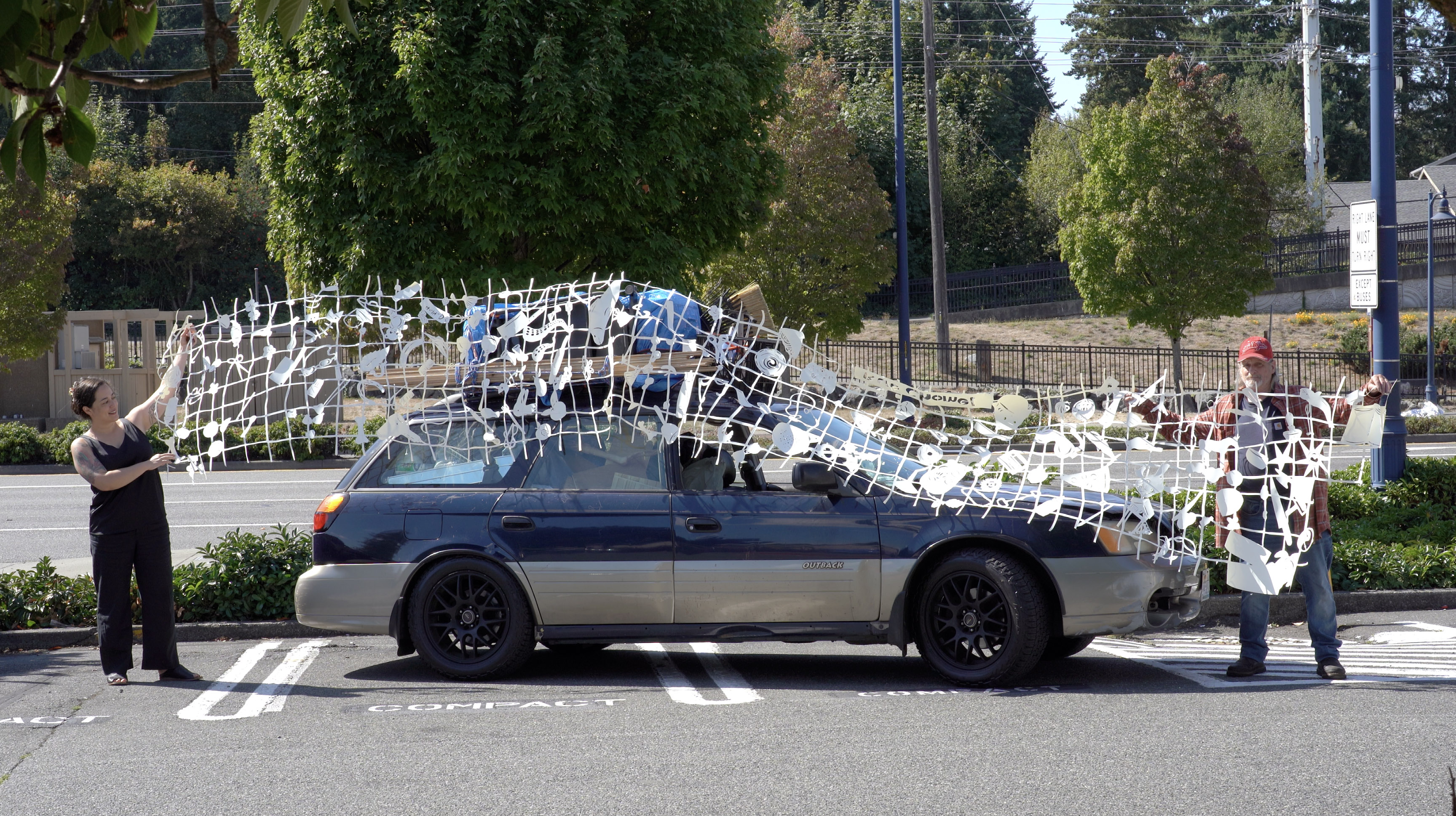 Lauren Iida's hand-cut paper art installation on a car during Holiday Drive